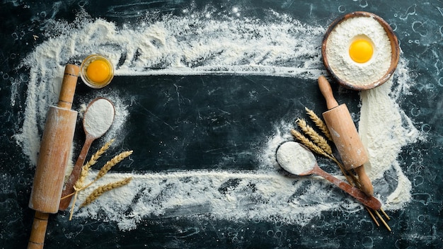 Fond de boulangerie Oeufs de farine rouleau à pâtisserie pour la pâte sur fond noir Vue de dessus Espace libre pour le texte