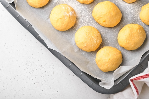 Fond de boules de pâte à levure crue dans une poêle à frire avant la cuisson. Concept maison faisant du pain, des petits pains ou du cinnabon ou faire de la pâte.