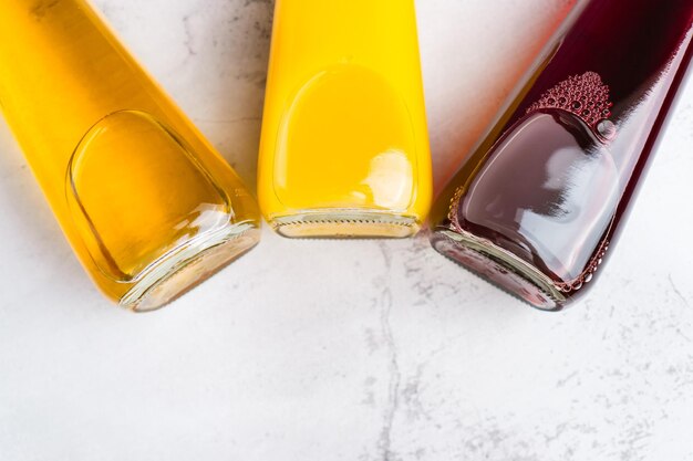 Fond de bouteilles avec boisson liquide jaune et rouge sur fond gris Jus de pomme orange et cerise