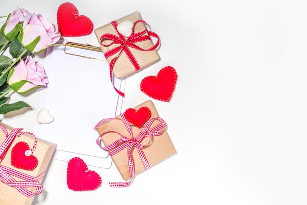 Fond de carte de voeux Saint Valentin. Ensemble de différents coffrets cadeaux Valentines, artisanat, coeur, ruban rouge, sur fond blanc