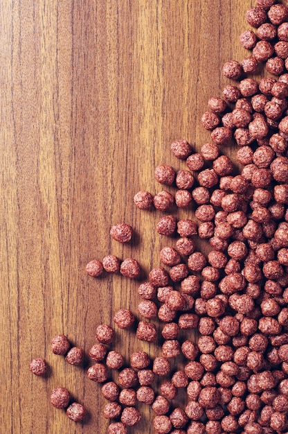 Fond avec des céréales au chocolat sur table en bois