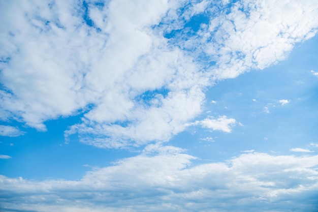 Fond de ciel bleu nuageux avec des nuages blancs moelleux