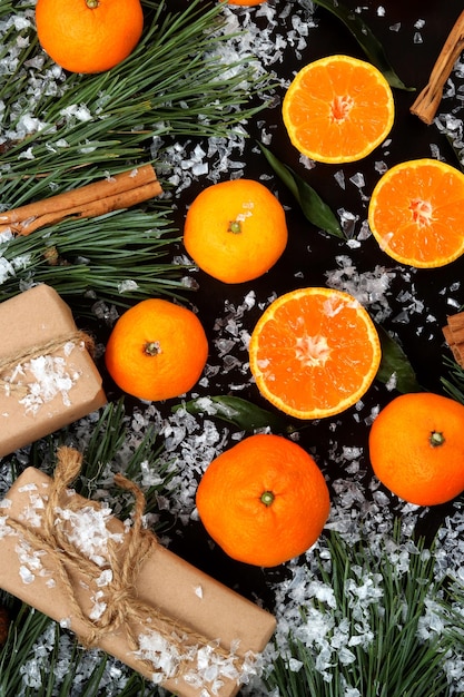 Fond de composition de Noël recouvert de neige avec vue de dessus de mandarines coupées et entières