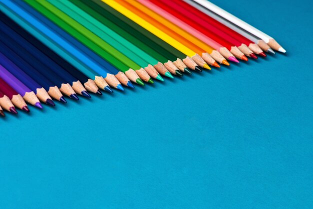 Photo fond de crayons de couleur sur papier bleu