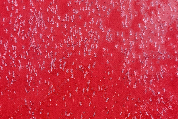 Fond de cristaux de flocon de neige congelés sur une surface rouge