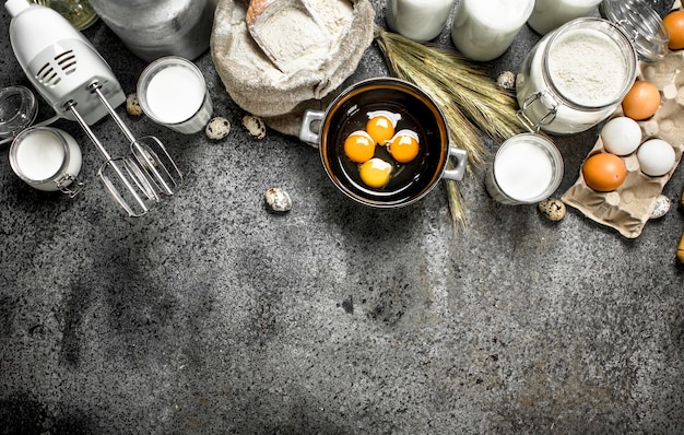 Fond de cuisson. Lait, farine et autres ingrédients pour la pâte. Sur un fond rustique.