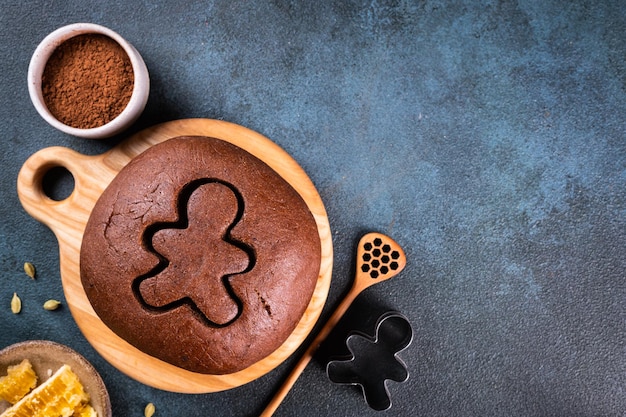 Fond de cuisson de Noël. Ingrédients pour la cuisson de Noël sur fond sombre. Vue de dessus avec espace de copie. Biscuits au gingembre. Faire des biscuits au gingembre. Pâte crue pour biscuits