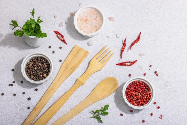 Fond culinaire avec des épices et des herbes d'ustensiles de cuisine en bois ensemble pour la préparation d'aliments sains plat poser lumière dure ombre sombre pierre claire fond en béton vue de dessus