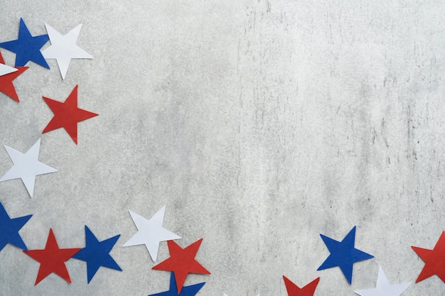 Fond du 4 juillet Éventails en papier des États-Unis Étoiles blanches bleues rouges et confettis sur fond gris vieux mur de béton Bonne fête du travail Fête de l'indépendance Fête des présidents Couleurs du drapeau américain Maquette