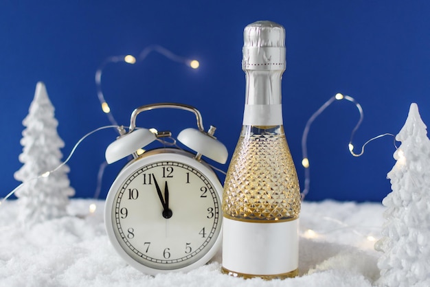 Fond du Nouvel An avec bouteille de champagne et horloge comptant jusqu'à minuit