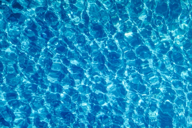 Fond d'eau d'ondulation bleue, réflexion du soleil sur l'eau de la piscine