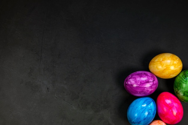 Fond élégant avec des oeufs de pâques peints colorés isolés sur fond de béton foncé pour le web de