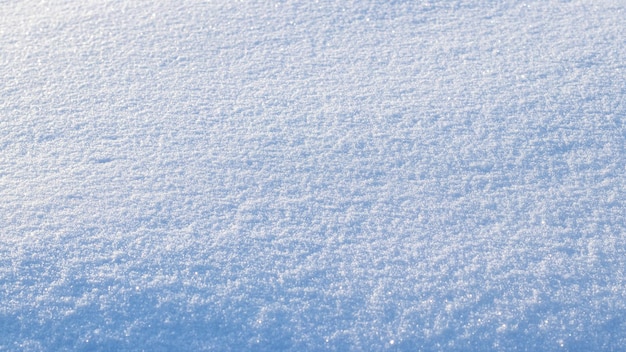 Fond enneigé, surface enneigée avec une texture clairement exprimée de neige au soleil du matin