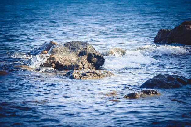 Fond d'énormes rochers dans la mer près du rivage, filtre