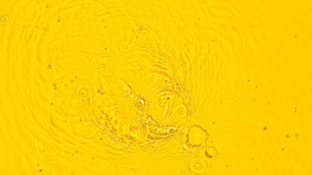 Fond d'été abstrait Texture de surface de l'eau claire jaune transparente avec des éclaboussures d'ondulations