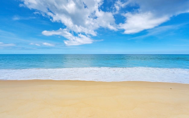 Fond d'été de la belle plage de sable Vague s'écrasant sur le rivage de sable Vue sur la nature du paysage Baie romantique de l'océan avec de l'eau bleue et un ciel bleu clair sur la mer à l'île de Phuket en Thaïlande.