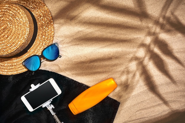 Fond d'été avec bouteille de crème solaire lunettes de soleil chapeau de paille et tongs