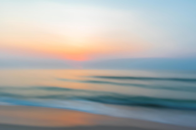 Photo fond d'été avec le lever du soleil du matin sur la plage floue