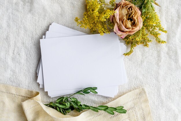 Fond féminin à la mode sur des fleurs en tissu blanc et une carte postale vide