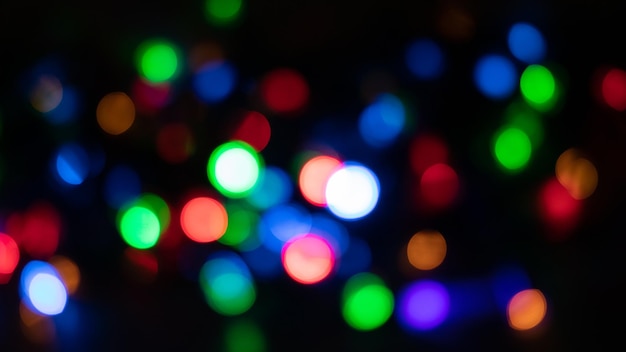 Fond festif de Noël et du nouvel an avec des lumières floues bokeh sur fond noir