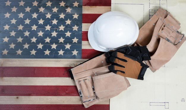 Fond de la fête du travail avec drapeau en bois rustique des États-Unis dessinant des imprimés bleus et des outils industriels utilisés plus