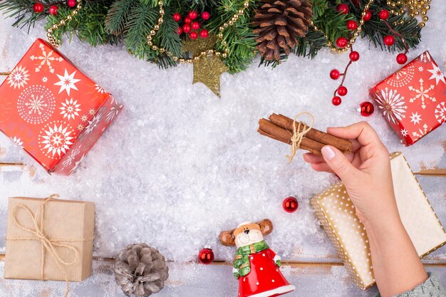 Sur un fond de fête de Noël, une main féminine expose des décorations