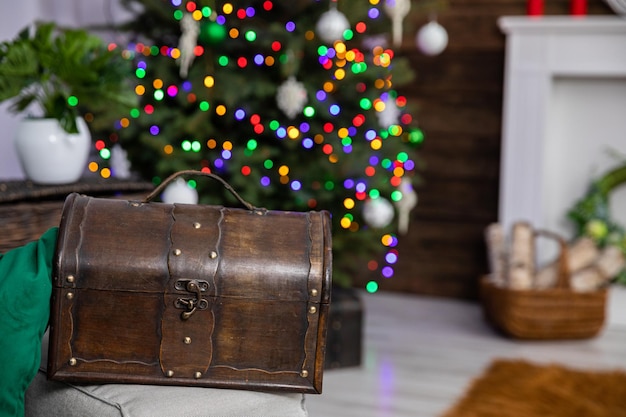 Sur le fond flou d'un arbre de Noël avec des lumières de Noël se trouve une vieille boîte en bois