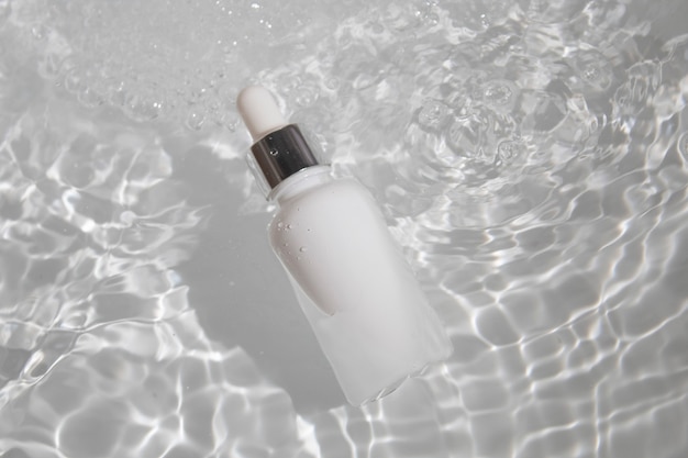 Fond frais d'eau blanche, produit cosmétique de crème de lotion de bouteille de maquillage avec la maquette de soins de santé de mode de beauté