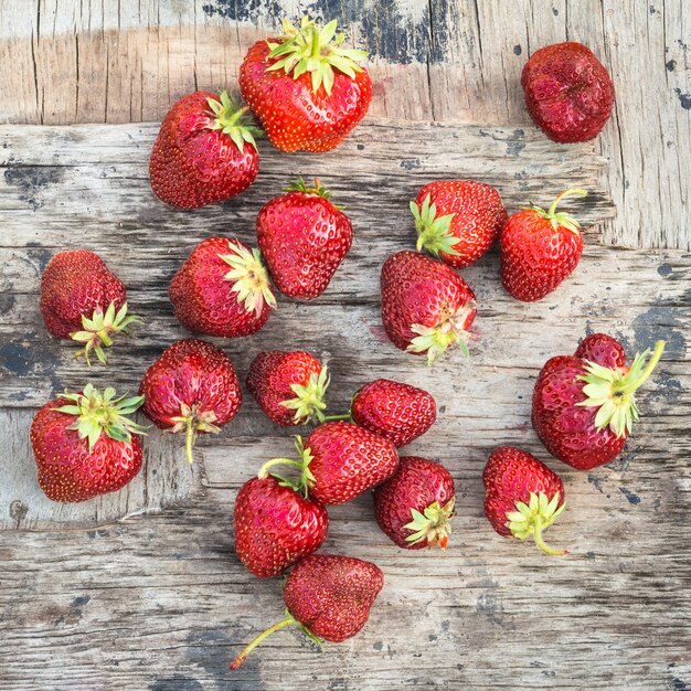 Fond avec une fraise mûre rouge sur une planche de bois