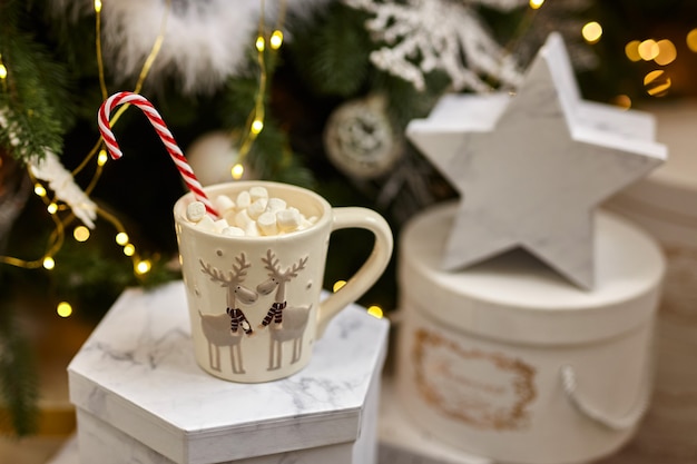 Fond de guirlandes lumineuses, chocolat chaud avec des guimauves