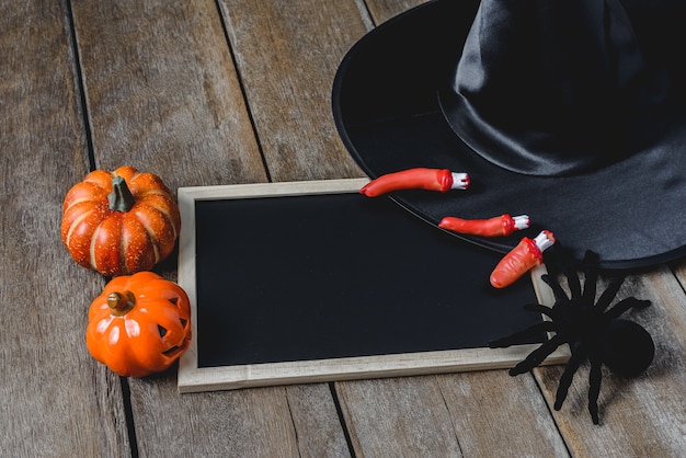 Fond d&#39;Halloween avec des citrouilles, chapeau de sorcière, araignée, doigts et tableau noir