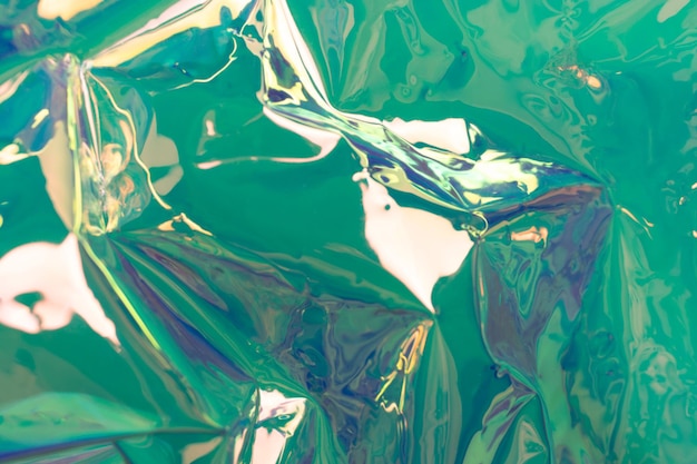Fond holographique turquoise Matériau en feuille froissé Ondes fluides à mise au point douce