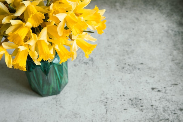 Fond incroyable avec bouquet jaune de jonquilles dans un vase sur un fond de béton gris Belle carte de voeux pour la fête des mères Pâques Journée de la femme