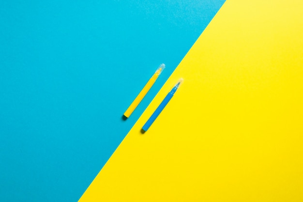 Fond jaune et bleu coloré avec deux stylos