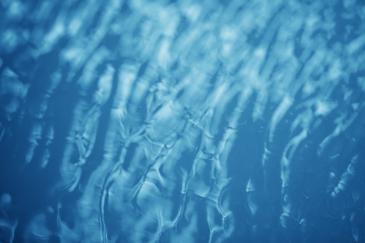 Photo le fond lisse de l'eau bleue naturelle avec résumé de bokeh sur la mer