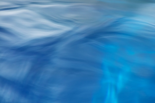 Photo le fond lisse de l'eau bleue naturelle avec résumé de bokeh sur la mer