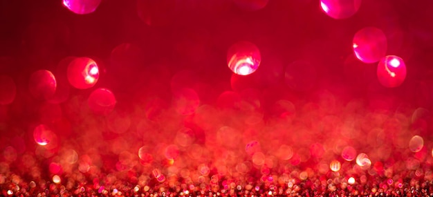 Fond de lumières de Noël rouge, conception de bannières. Surface brillante et brillante avec bokeh, paillettes défocalisées abstraites avec des étincelles