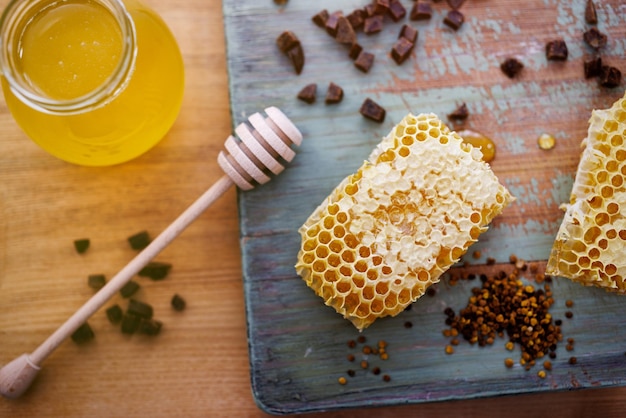 Photo fond de miel miel doux dans un bocal en verre nids d'abeilles propolis et pollen sur la table