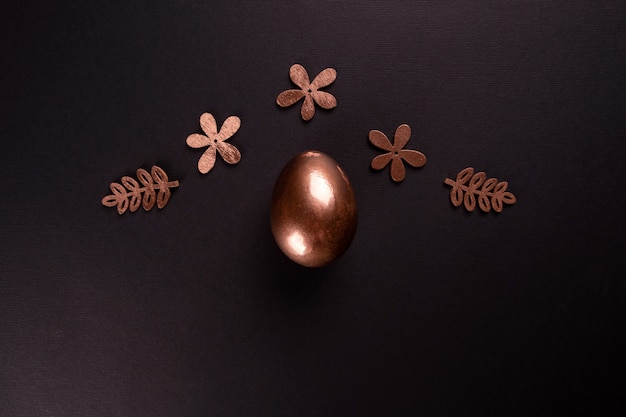 Fond minimal de Pâques avec des oeufs de Pâques en or sur fond noir. Mise à plat, vue de dessus, espace copie.