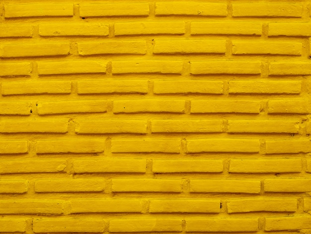 Fond de mur de brique jaune.