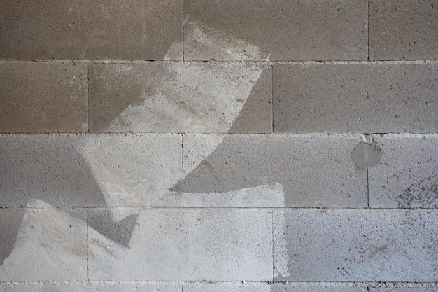 Fond avec un mur de texture de surface rugueuse de blocs de béton avec des traces de peinture et de plâtre