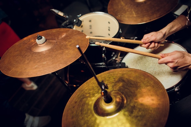 Fond de musique live aux tons vintage, le batteur joue avec des baguettes sur un ensemble de batterie rock