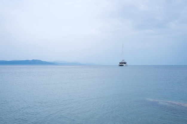 Fond de nature mystérieuse magnifique avec yacht sur l&#39;océan contre les montagnes brumeuses