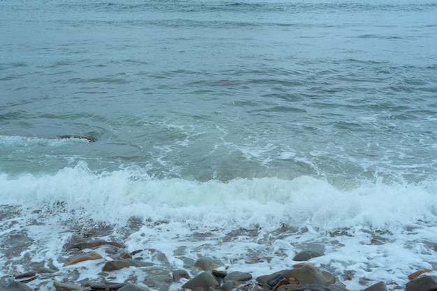 Fond de nature avec des vagues de la mer frappant le bord de la mer Vue panoramique de la mer contre un ciel nuageux