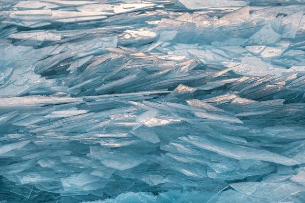 Fond naturel de glace bleue cassée en hiver avec des reflets du soleil dans le givre