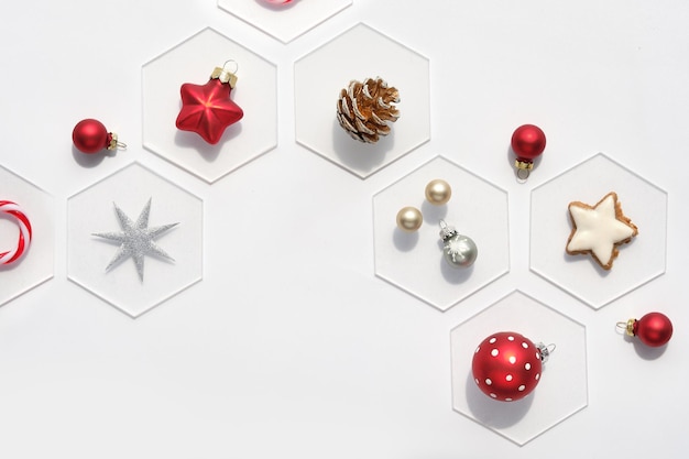 Fond de Noël abstrait avec décor de Noël sur des hexagones blancs sur fond blanc cassé avec fond Biscuit étoile de cône de pin boules d'argent rouge Vue de dessus plat poser fond simple minimal