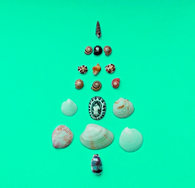Fond de Noël avec arbre de Noël fait de coquillages sur fond de menthe copie espace Tropical