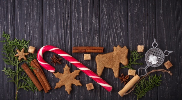 Fond de Noël avec des biscuits, des arbres et de la cannelle. Mise au point sélective, vue de dessus