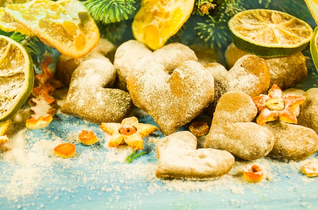 Fond de Noël avec des biscuits de branches de sapin saupoudrés de sucre en poudre sur planche de bois