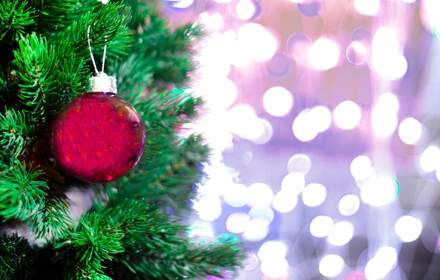 Fond de Noël boule de Noël rouge et branche de sapin sur le fond d'une guirlande